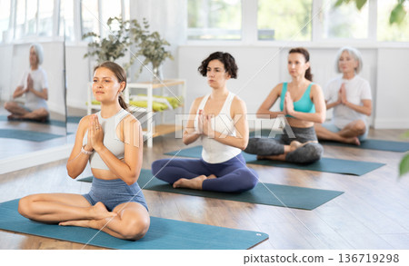 Young woman doing yoga in group in studio Young woman doing yoga in group in studio 136719298