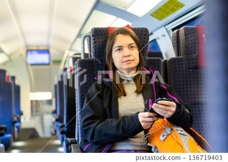 Woman sitting on her seat while traveling by train 136719403