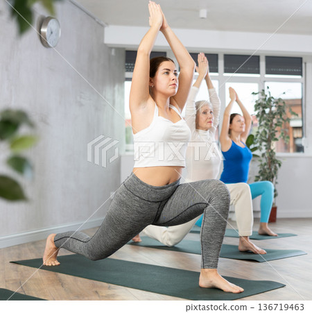 Active women practice the Anjanasana pose Active women practice the Anjanasana pose 136719463