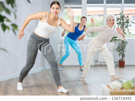 Girl practicing aerobics during group workout in fitness studio 136719485