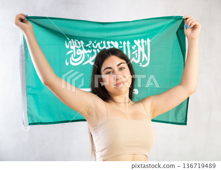 Young woman with flag of Saudi Arabia posing in studio 136719489