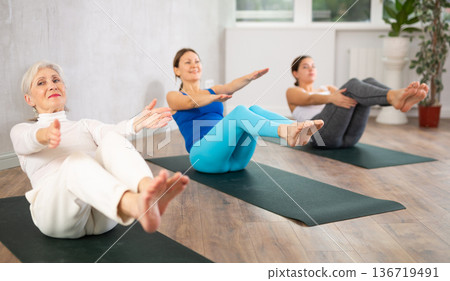 Elderly woman doing yoga in fitness studio 136719491