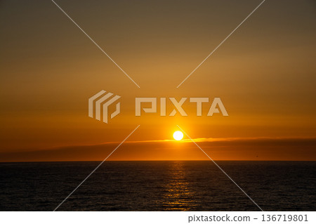 海上美麗的日落，橙色的雲彩倒映在海面上。 136719801