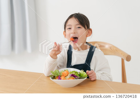 Girl eating vegetable salad Girl eating vegetable salad 136720418