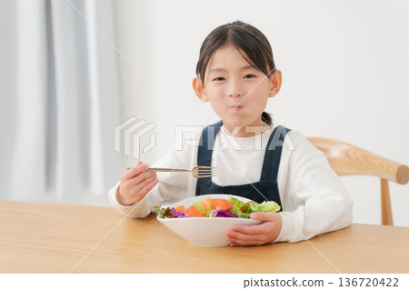 Girl eating vegetable salad Girl eating vegetable salad 136720422