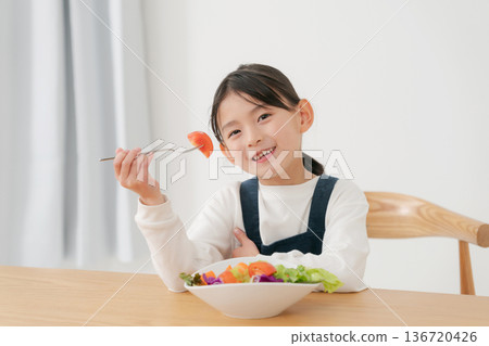 Girl eating vegetable salad Girl eating vegetable salad 136720426