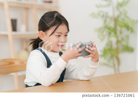 Elementary school girl looking at smartphone 136721061