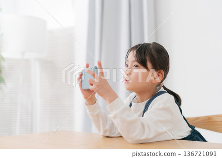 玩智慧型手機的小學生女孩 玩智慧型手機的小學生女孩 136721091
