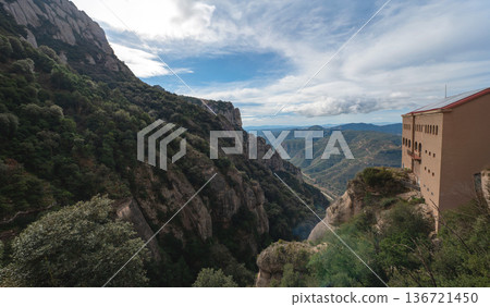 Panoramic view of the majestic Montserrat mountains and monastery buildings perched on a steep cliff in Catalonia, Spain. A breathtaking natural and historic landmark 136721450