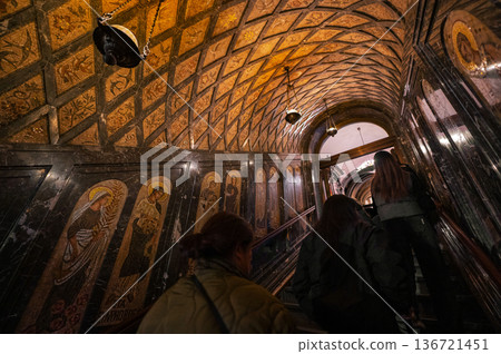 Interior view of Montserrat Monastery in Spain, featuring an ornate iron gate, religious paintings Interior view of Montserrat Monastery in Spain, featuring an ornate iron gate, religious paintings 136721451