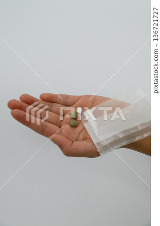 Supplements and medicine bags in the palm of your hand 136721727