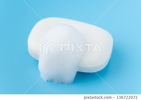 一塊白色的肥皂和泡泡，背景是淺藍色背景。 136722072