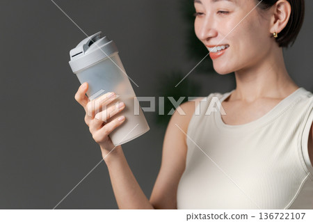 Woman in sportswear holding protein Woman in sportswear holding protein 136722107