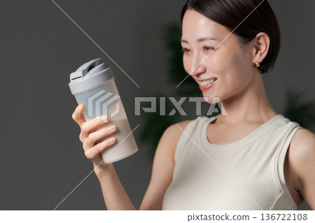 Woman in sportswear holding protein Woman in sportswear holding protein 136722108