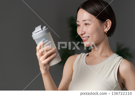 Woman in sportswear holding protein Woman in sportswear holding protein 136722110