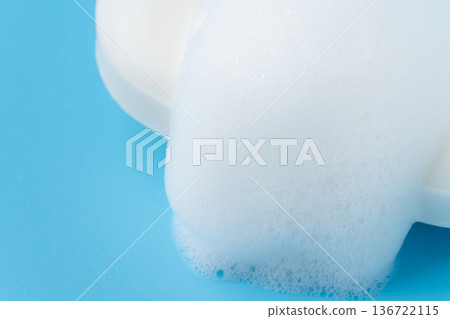 淺藍色背景上，一塊起泡的白色香皂的特寫鏡頭 136722115