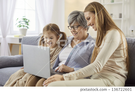 Old grandmother adult daughter and granddaughter using laptop computer 136722601