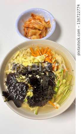 Janchi Guksu, a light and savory Korean noodle dish served in a clear broth, topped with vegetables, egg strips, and seaweed. A simple yet flavorful meal often enjoyed on special occasions. Janchi Guksu, a light and savory Korean noodle dish served in a clear broth, topped with vegetables, egg strips, and seaweed. A simple yet flavorful meal often enjoyed on special occasions. 136722774