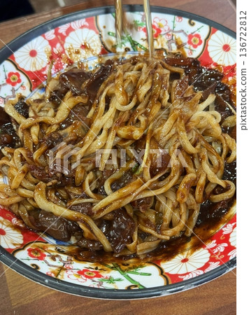 Classic jajangmyeon with thick noodles in a rich black bean sauce, garnished with sliced cucumber and sesame seeds. A beloved Korean-Chinese comfort dish, full of savory depth and flavor. Classic jajangmyeon with thick noodles in a rich black bean sauce, garnished with sliced cucumber and sesame seeds. A beloved Korean-Chinese comfort dish, full of savory depth and flavor. 136722812