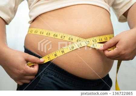 Asian woman with fat belly big size overweight and obesity with measure tape. Asian woman with fat belly big size overweight and obesity with measure tape. 136722865