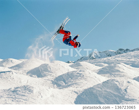 A backflip into the clear blue sky. A dynamic aerial jump by a mogul skier A backflip into the clear blue sky. A dynamic aerial jump by a mogul skier 136723065