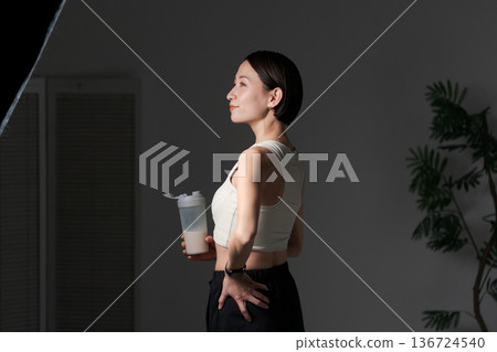 Woman in sportswear holding protein 136724540
