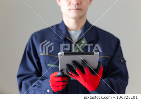 一位身著工作服的中年男性商務人士手持平板電腦 一位身著工作服的中年男性商務人士手持平板電腦 136725191