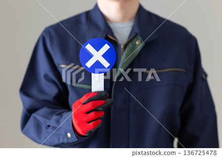 Middle-aged male businessman in work clothes holding a round cross plate 136725478