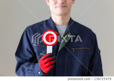 A middle-aged male businessman in work clothes holding a round plate 136725479