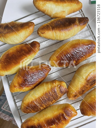 Golden brown salt bread with a soft, fluffy interior and a perfectly crisp crust, lightly sprinkled with coarse salt for a savory touch. A simple yet satisfying treat for any occasion. 136725516