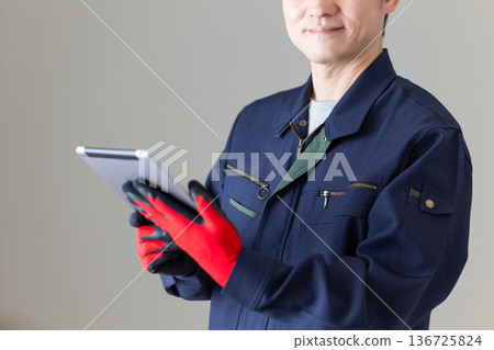 Middle-aged male businessman in work clothes holding a tablet Middle-aged male businessman in work clothes holding a tablet 136725824