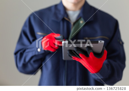 Middle-aged male businessman in work clothes holding a tablet Middle-aged male businessman in work clothes holding a tablet 136725828