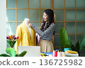 Young women fashion designer using laptop working and design tailor and cloth in the showroom,  136725982