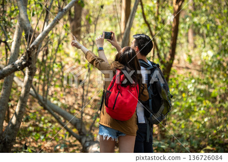 Tourist and traveler asian couple backpack enjoy and happy the jungle forest nature park Tourist and traveler asian couple backpack enjoy and happy the jungle forest nature park 136726084