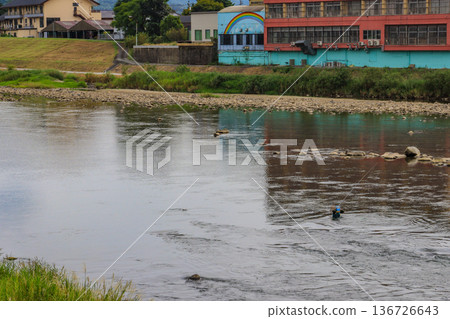 A man enjoying fishing with a long rod in the river 136726643