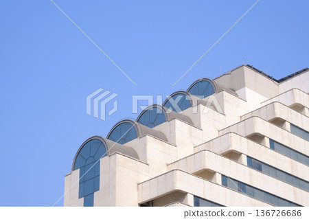 現代建築外觀,拱形窗戶映襯著藍天。 現代建築外觀,拱形窗戶映襯著藍天。 136726686