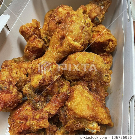 Crispy Korean fried chicken, perfectly glazed with a sweet and spicy sauce. Ideal for food photography and menus, showcasing the irresistible crunch and flavor of this beloved dish. 136726956