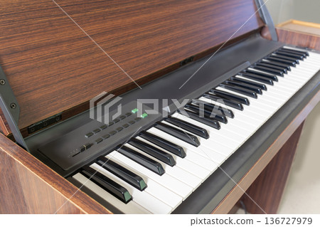 An image of a digital piano with a calming wood grain design taken from an angle 136727979