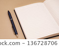 筆記本和鋼筆，背景溫暖。 136728706