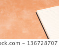 一本在橘色背景下格外醒目的筆記本 136728707