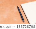 橙色背景上的筆記本和鋼筆 136728708