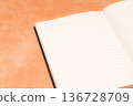 一本在橘色背景下格外醒目的筆記本 136728709