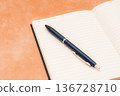 橙色背景上的筆記本和鋼筆 136728710