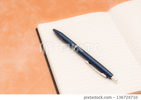 橙色背景上的筆記本和鋼筆 136728710