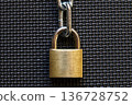 A locked padlock and chain on a black mat 136728752