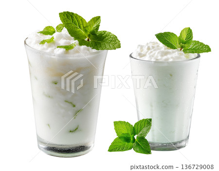 Ayran salted yogurt drink in tall glass with foamy top and mint leaf, isolated on white background, concept of healthy drink Ayran salted yogurt drink in tall glass with foamy top and mint leaf, isolated on white background, concept of healthy drink 136729008