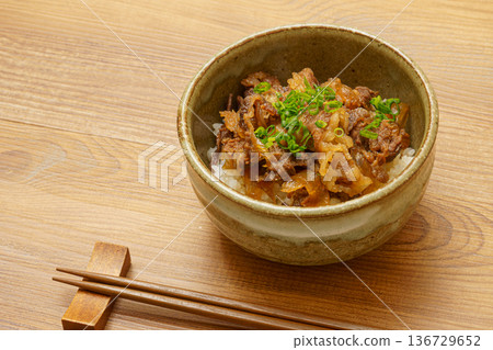 Japanese food image of beef bowl and chopsticks placed on a wood-grain table Japanese food image of beef bowl and chopsticks placed on a wood-grain table 136729652