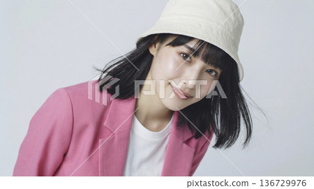 特寫鏡頭：一位面帶微笑的日本女性，身穿粉紅色外套，頭戴白色帽子。 136729976