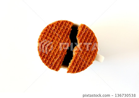 A stroopwafel split in two and coffee on a white background, viewed from above 136730538