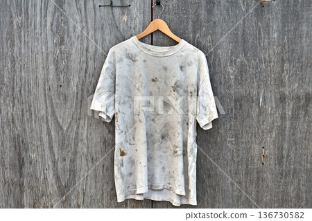 Dirty white t-shirt hanging on plywood 136730582